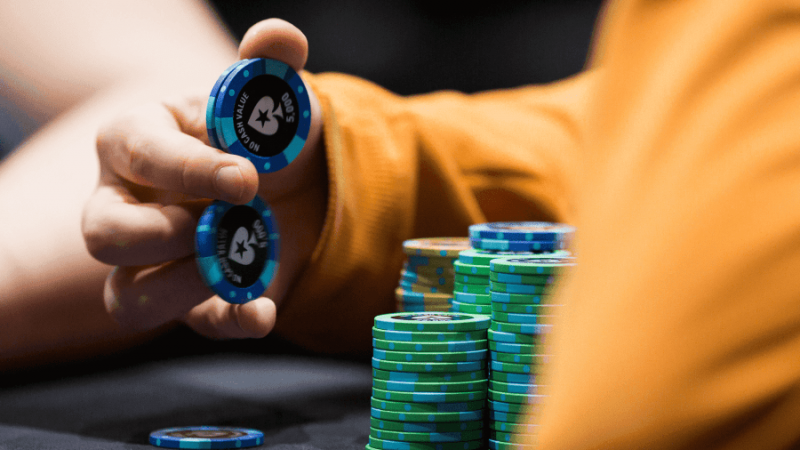 A poker player balancing poker chips in his hands.