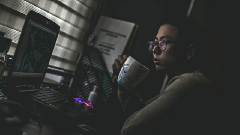 A person studying poker while drinking coffee.